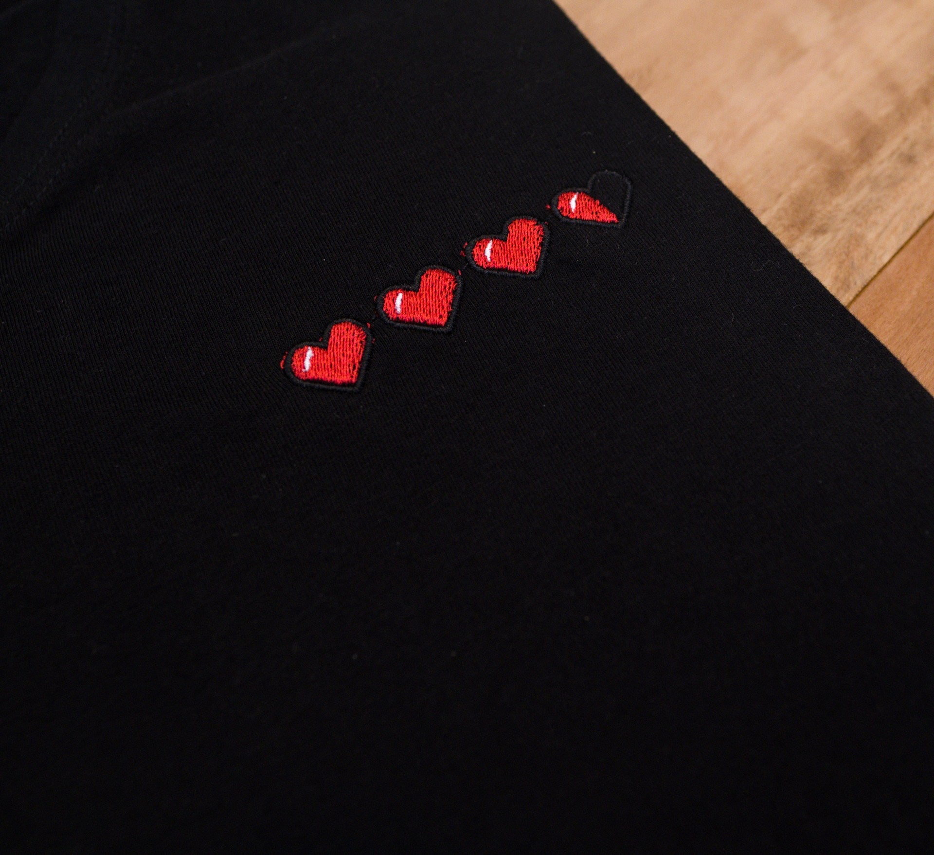 Close up of 3 and a half hearts embroidered  on a t-shirt