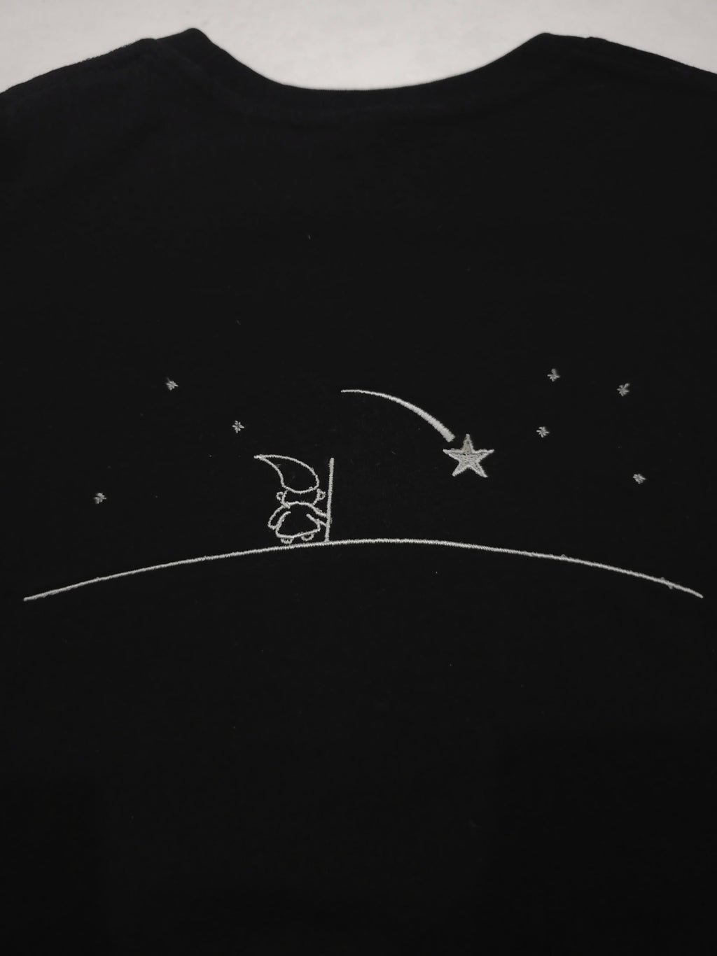 Black shirt with silver outline design of a Wizard looking into the nights sky