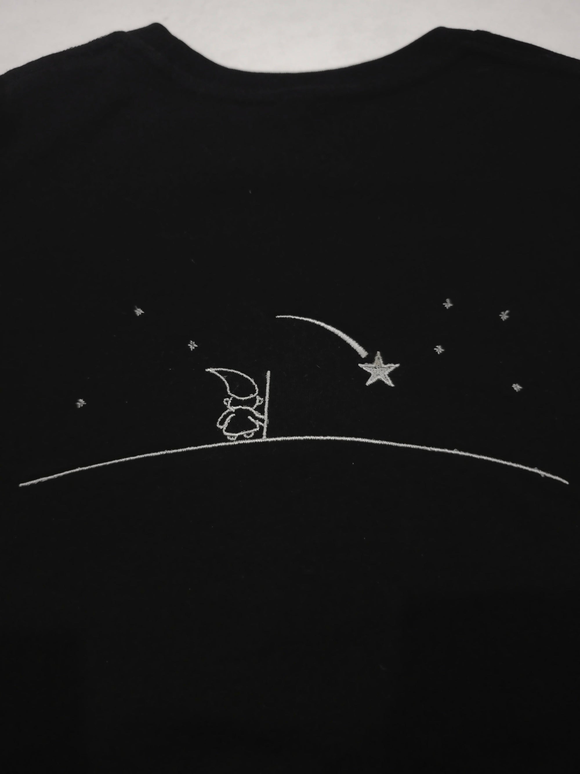 Black shirt with silver outline design of a Wizard looking into the nights sky